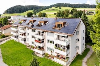 Mehrfamilienhaus mit installierter Photovoltaikanlage über ganze Dachfläche